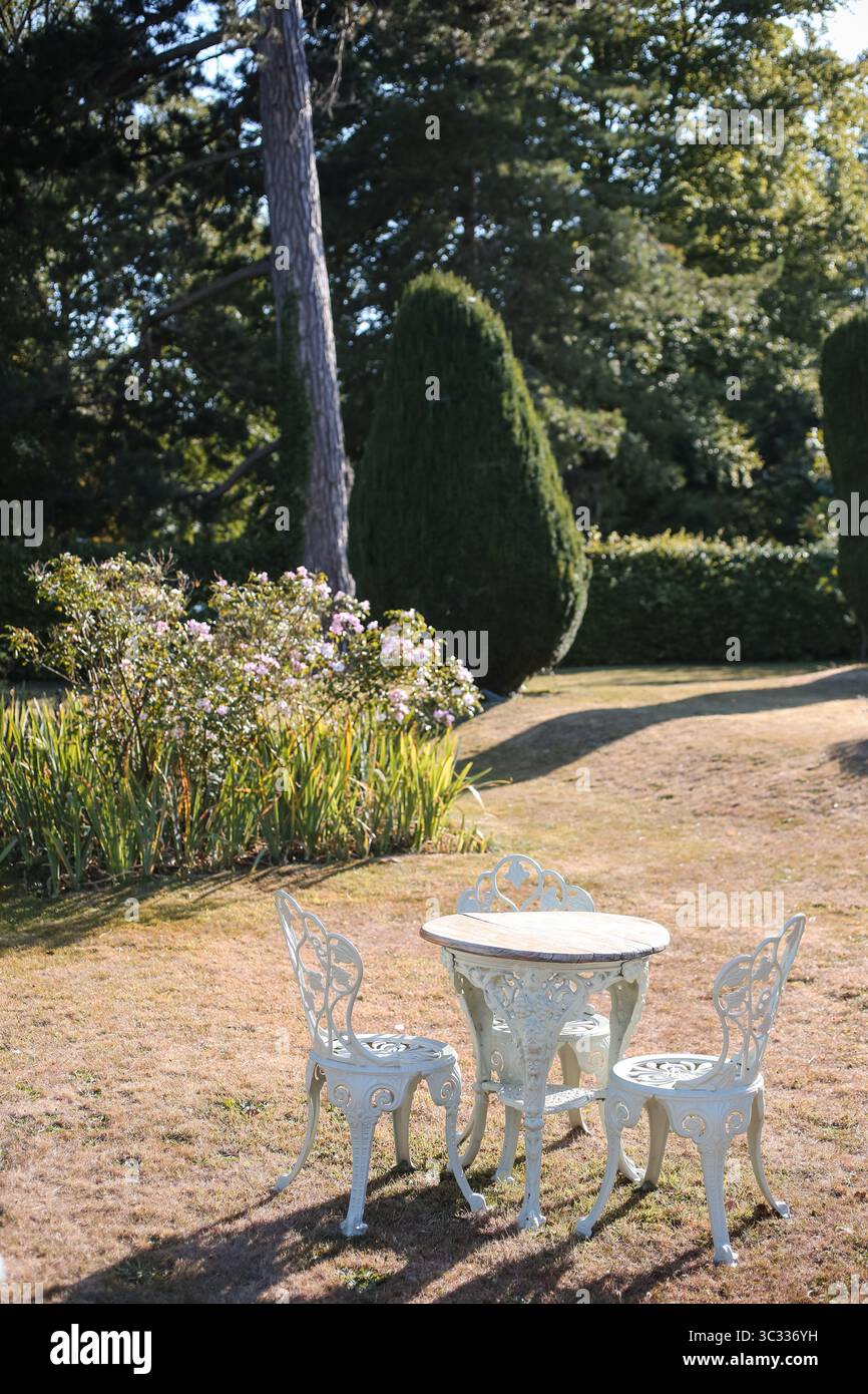 Tavolo e sedie da giardino vintage nel Sunny Formal Landscape Foto Stock