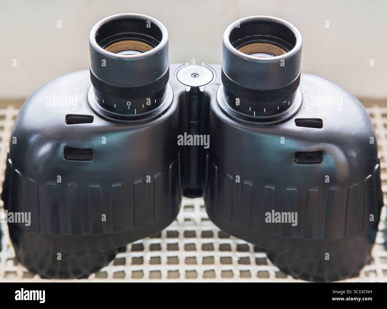 Binocolo su un ponte navale vicino all'oblò. Foto Stock
