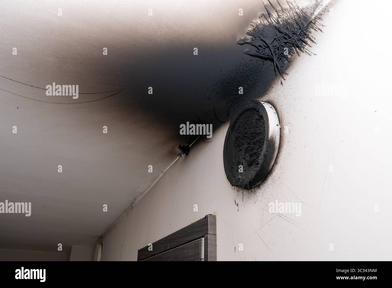 Lampada LED bruciata. Una lampada a paralume sulla parete dopo un incendio. Combustione spontanea e incendio in un edificio residenziale. Al chiuso Foto Stock