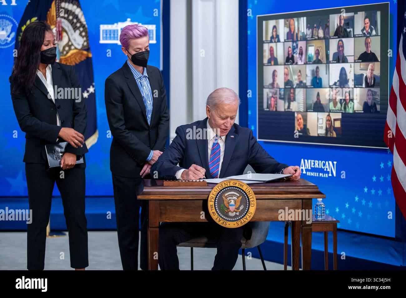 24 marzo 2021, Washington, District of Columbia, USA: Il presidente DEGLI STATI UNITI Joe Biden, con Margaret Purce (L), Megan Rapinoe (C) e altri membri della squadra nazionale degli Stati Uniti Soccer womenÂ, firma un proclama durante un evento per celebrare l'Equal Pay Day nella State Dining Room della Casa Bianca a Washington, DC, USA, 24 marzo 2021. Equal Pay Day segna il tempo extra che una donna media negli Stati Uniti impiega per guadagnare lo stesso stipendio che i suoi omologhi maschi hanno fatto l'anno precedente (Credit Image: © Shawn Thew - Pool via CNP/CNP via ZUMA Wire) Foto Stock