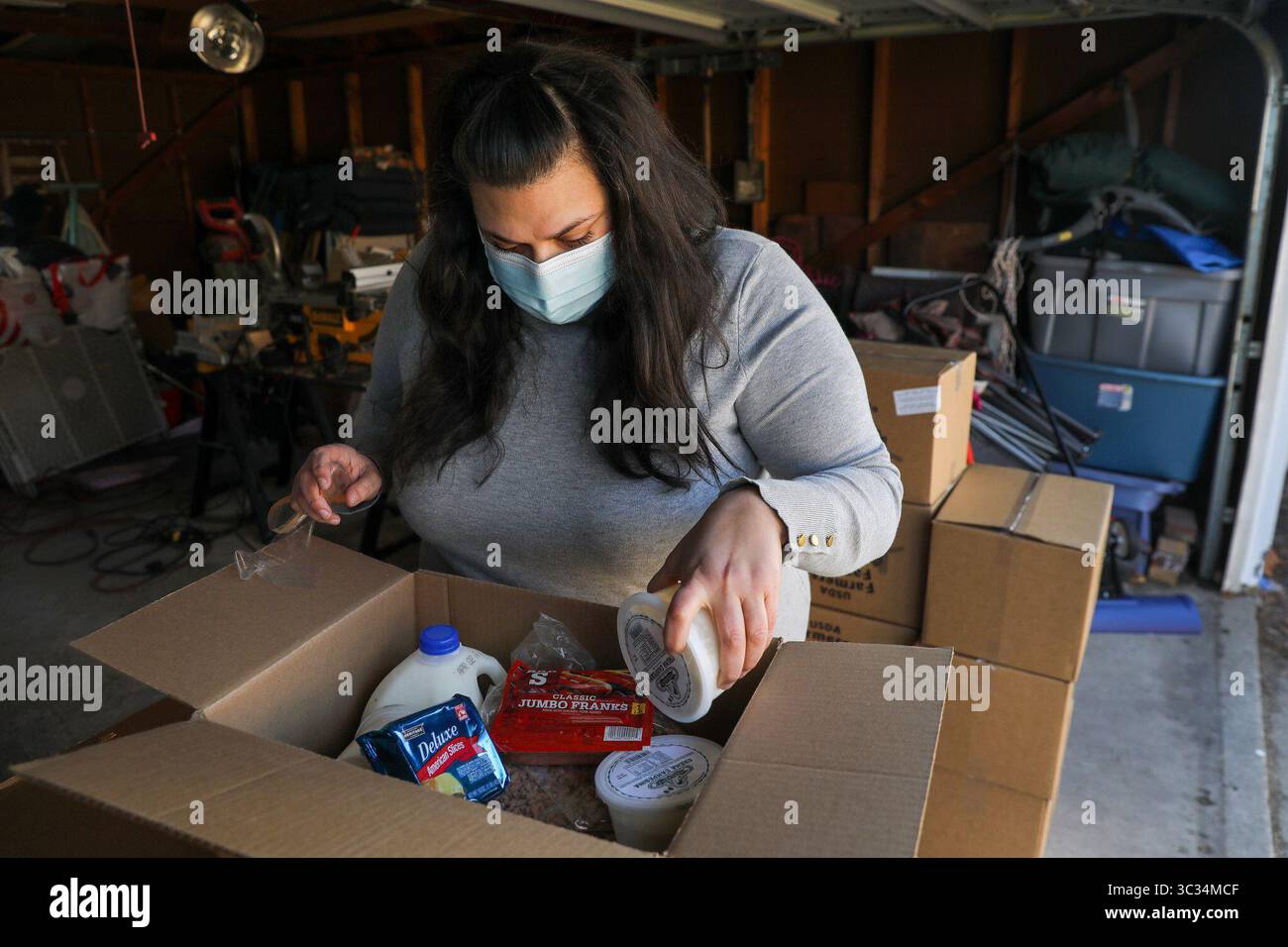 20 marzo 2021, USA: Karen Krausen-Ferrer, volontaria del West Ridge Community Response Team, guarda una delle 20 scatole di cibo che sono state consegnate al suo garage a Chicago venerdì 19 marzo 2021. Coordina le scatole del cibo e si assicura che vengano consegnate tutte. (Immagine di credito: © TNS via cavo ZUMA) Foto Stock 20 marzo 2021, USA: Karen Krausen-Ferrer, volontaria del West Ridge Community Response Team, guarda una delle 20 scatole di cibo che sono state consegnate al suo garage a Chicago venerdì 19 marzo 2021. Coordina le scatole del cibo e si assicura che vengano consegnate tutte. (Immagine di credito: © TNS via cavo ZUMA) Foto Stock