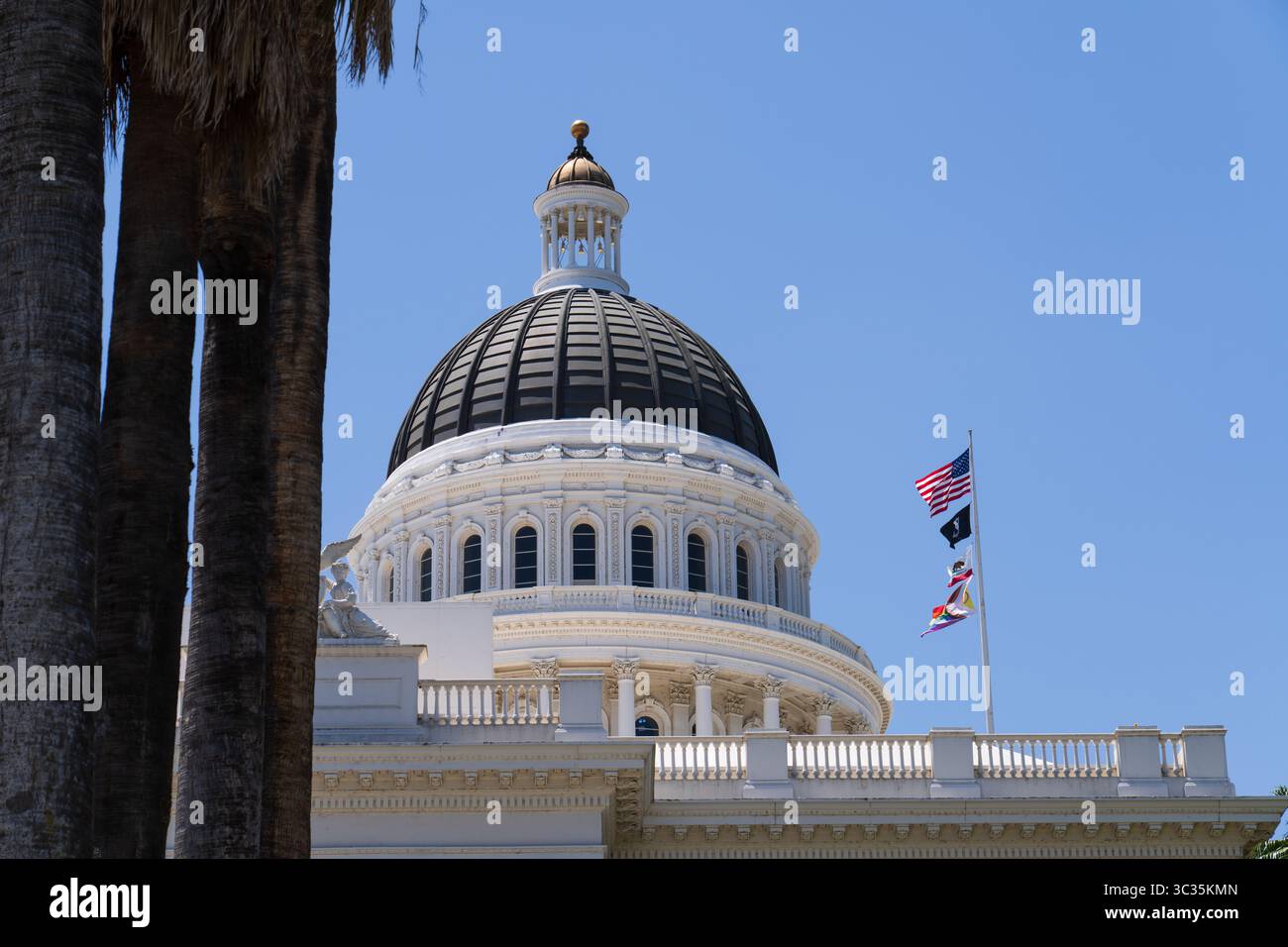 Sacramento, California, USA - 21 giugno 2025: Edificio storico del Campidoglio della California, vista laterale, con bandiere californiane, statunitensi e bandiera lgbtq Foto Stock