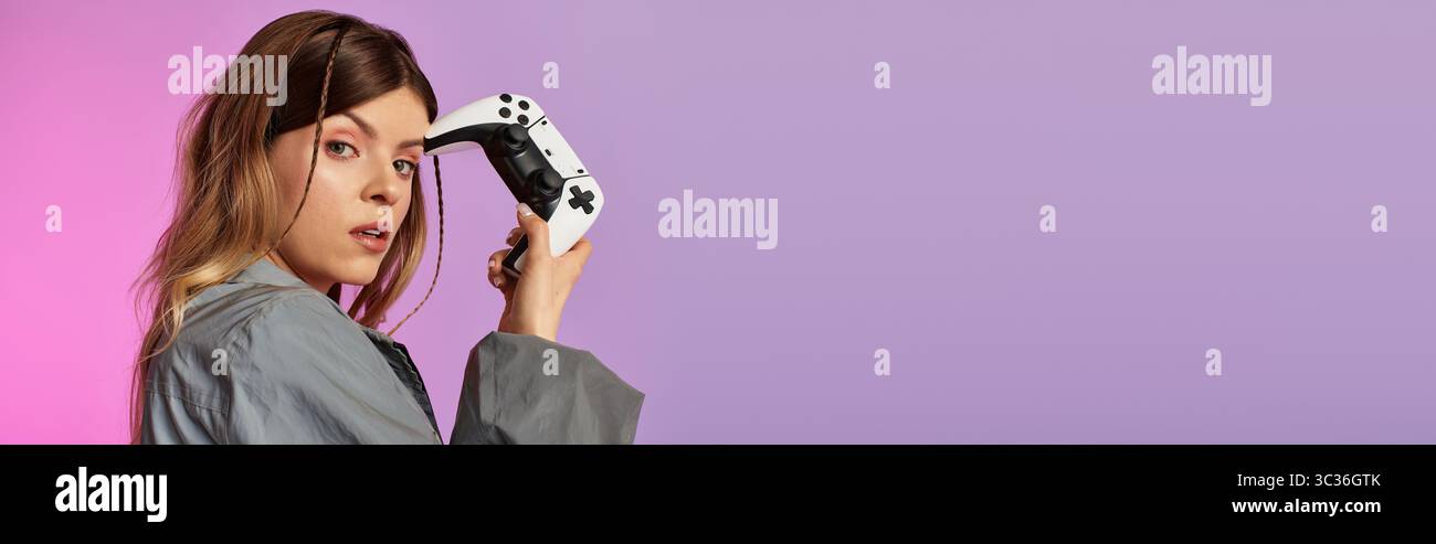 I colori brillanti si fondono mentre una giovane bella donna gioca ai videogiochi, irradiando energia estiva. Foto Stock