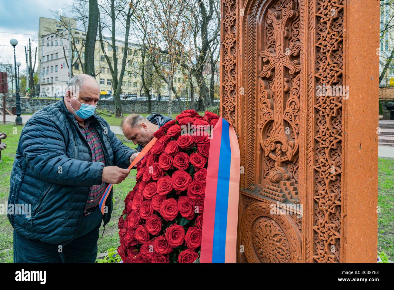 24 aprile 2021, Kiev, Kiev, Ucraina: Un uomo prepara un'offerta di fiori vicino a un khachkar, una stele commemorativa in pietra della cultura armena, durante il giorno della commemorazione del genocidio armeno a Kiev, Ucraina. (Immagine di credito: © Celestino Arce Lavin/ZUMA Wire) Foto Stock