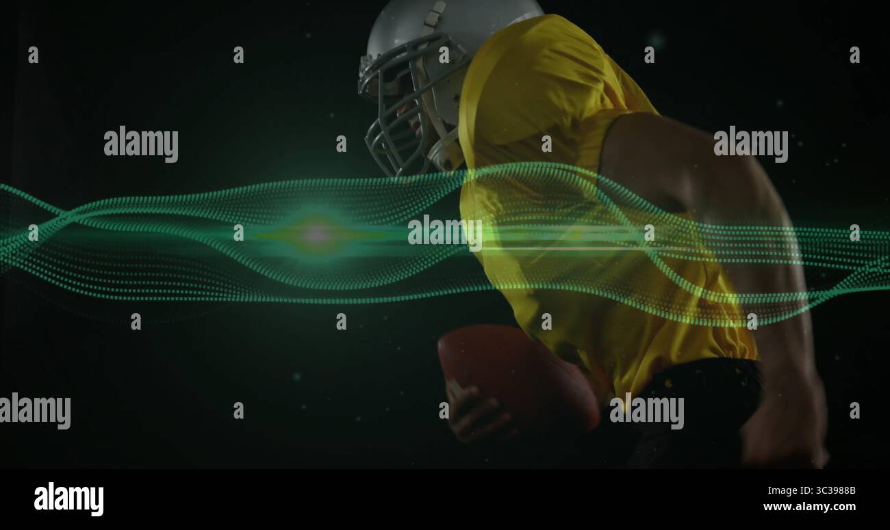 Giocatore di calcio in carica con casco in maglia gialla guanti e cuscinetti in studio con forma d'onda verde Foto Stock