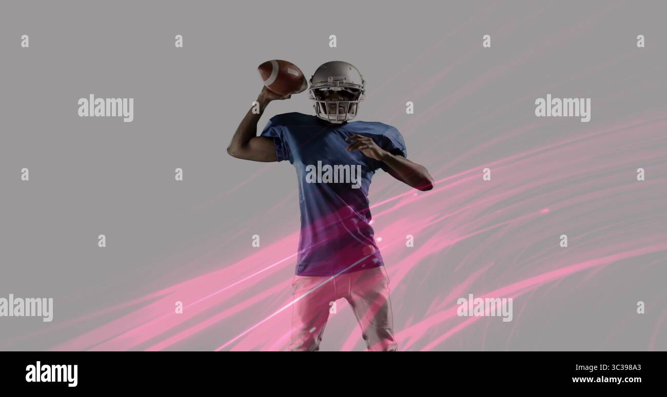 Tenere in mano il calcio, prepararsi a passare in studio, quarterback che indossa un casco con grafica rosa striata Foto Stock