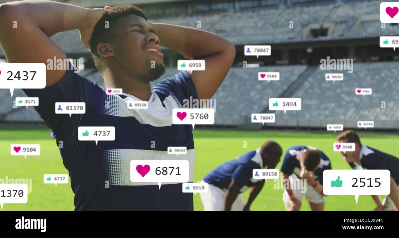 Giocatore di calcio con maglia blu navy in campo allo stadio, con icone fluttuanti dei social media Foto Stock