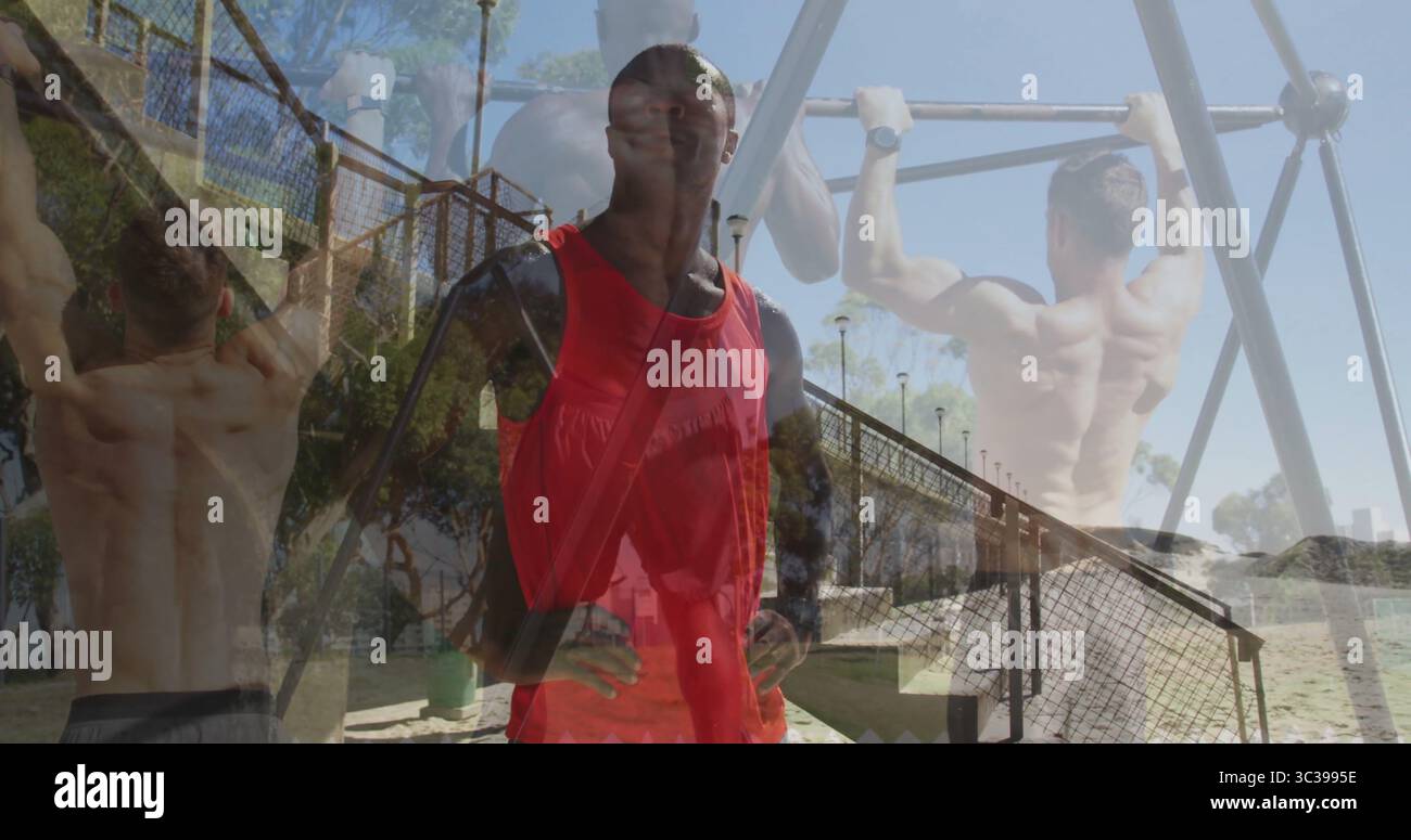Uomo con top rosso, maniche nere e tracolla che sorveglia i pull-up in spiaggia, con barre in metallo Foto Stock