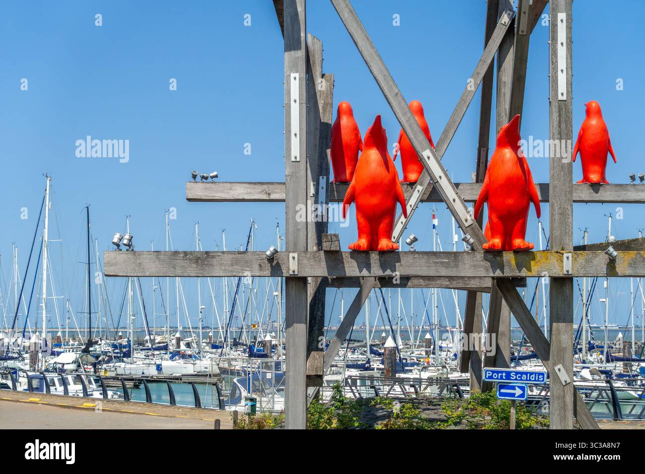 Rode Pinguins / Red Penguins, opera dell'artista belga William Sweetlove nella marina di Breskens lungo la Schelda occidentale, Zelanda, Paesi Bassi Foto Stock