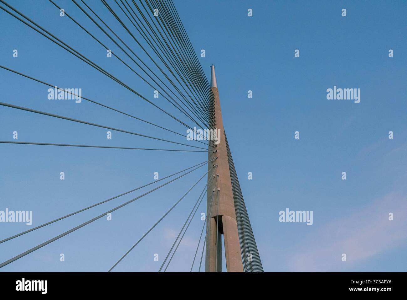 Vista minimalista di un moderno ponte strallato su un cielo azzurro, guardando dal basso Foto Stock