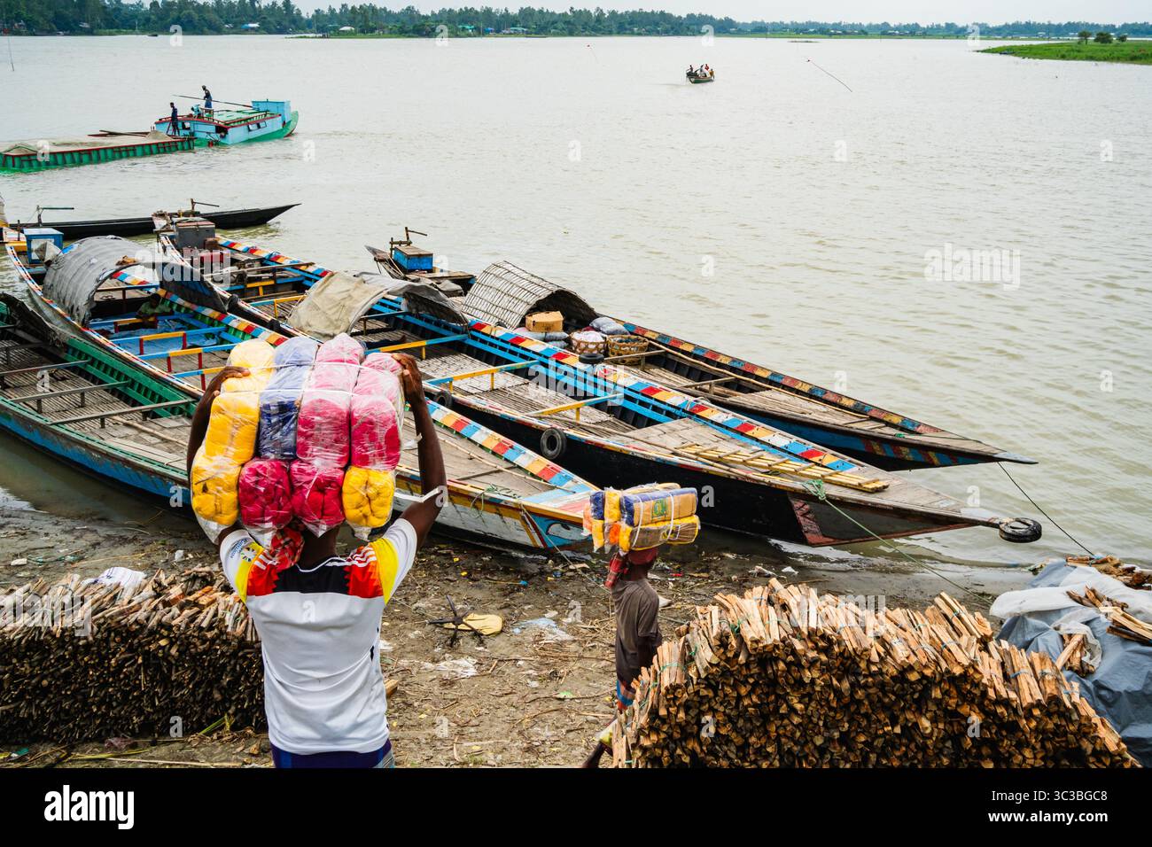 Un filo di trasporto umano utilizzato nell'industria tessile in barca e a piedi, una vivace scena di commercio e cultura quotidiana in Bangladesh Foto Stock