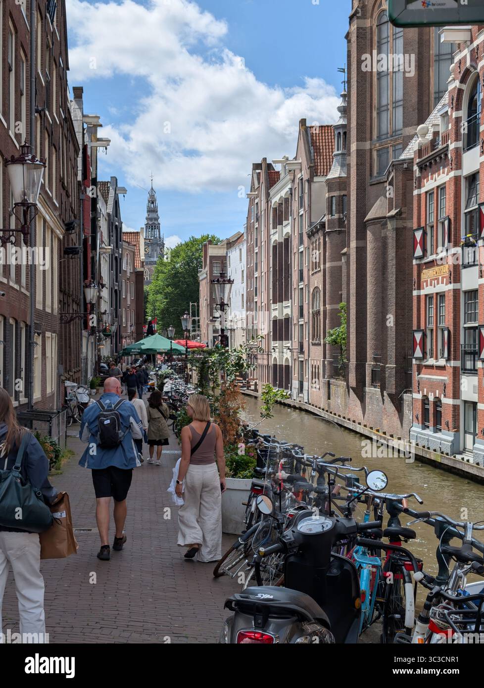 Biciclette e caffetterie fiancheggiano gli stretti canali di Amsterdam Foto Stock