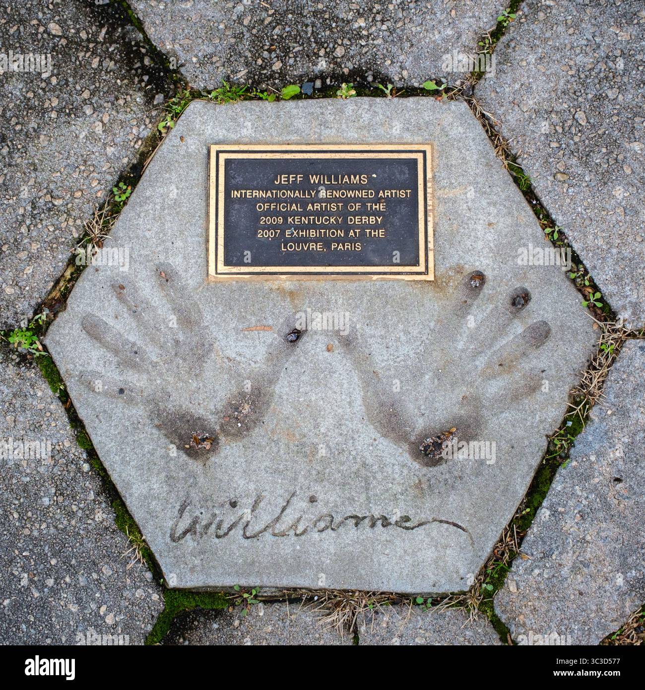 Impronte dell'artista Jeff Williams in cemento con una placca metallica. Foto Stock