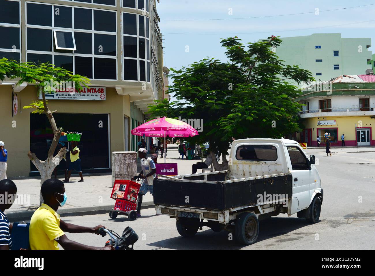 BENGUELA, ANGOLA - 13 febbraio 2025: Persone che camminano per la strada di Benguela. Tipica scena di strada Foto Stock