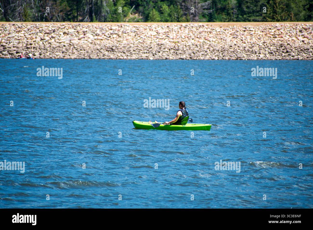 Oakley, Utah - 20 luglio 2025: Una donna pagaia in kayak attraverso le calme acque di Smith e Morehouse Reservoir durante una tranquilla gita estiva. Foto Stock