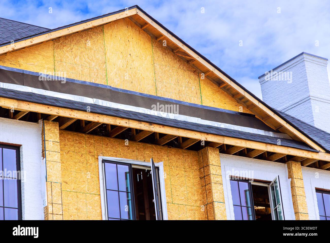 La nuova costruzione presenta finestre aperte con struttura in legno che riflettono i progressi durante il giorno dei lavori Foto Stock