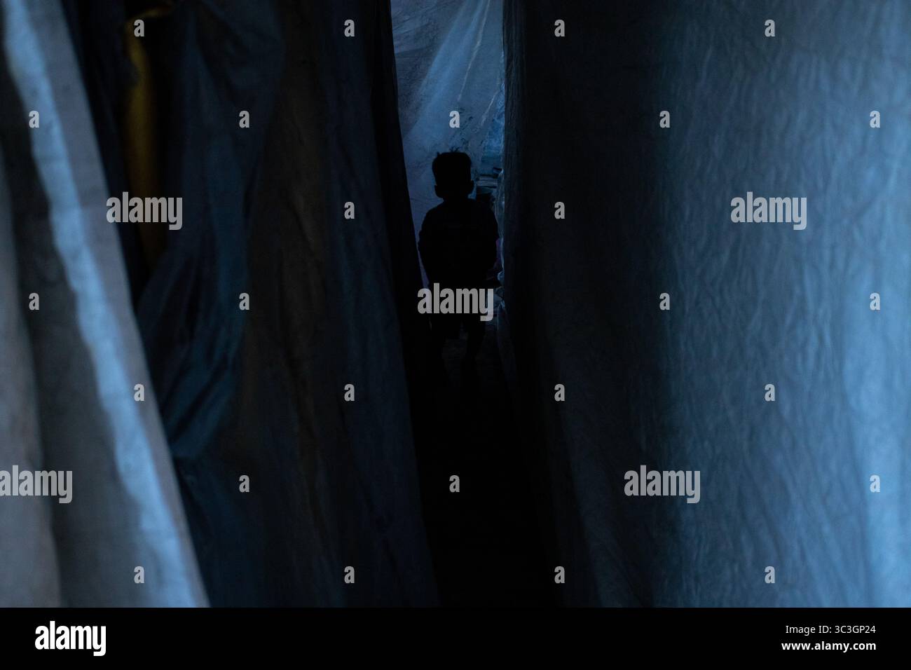 Il migrante sagomato naviga lungo il passaggio drappeggiato nei pressi di Ciudad Juarez. Foto Stock