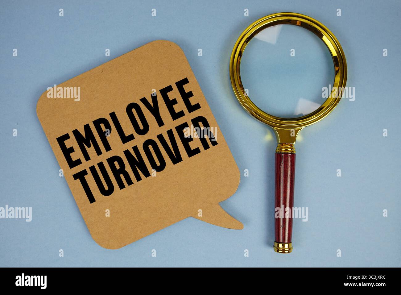 Testo del turnover dei dipendenti con lente d'ingrandimento su sfondo blu Foto Stock
