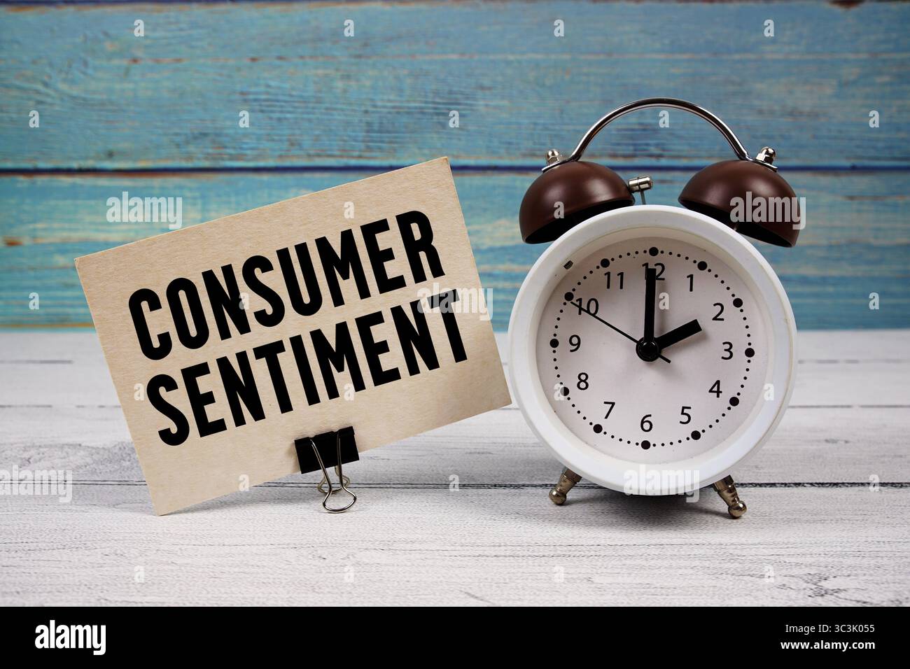 Testo del sentimento del consumatore scritto su carta con sveglia su sfondo di legno Foto Stock