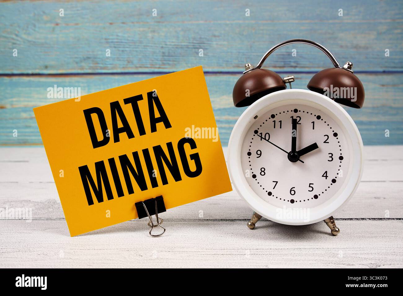 Testo data Mining scritto su carta con sveglia su sfondo in legno Foto Stock