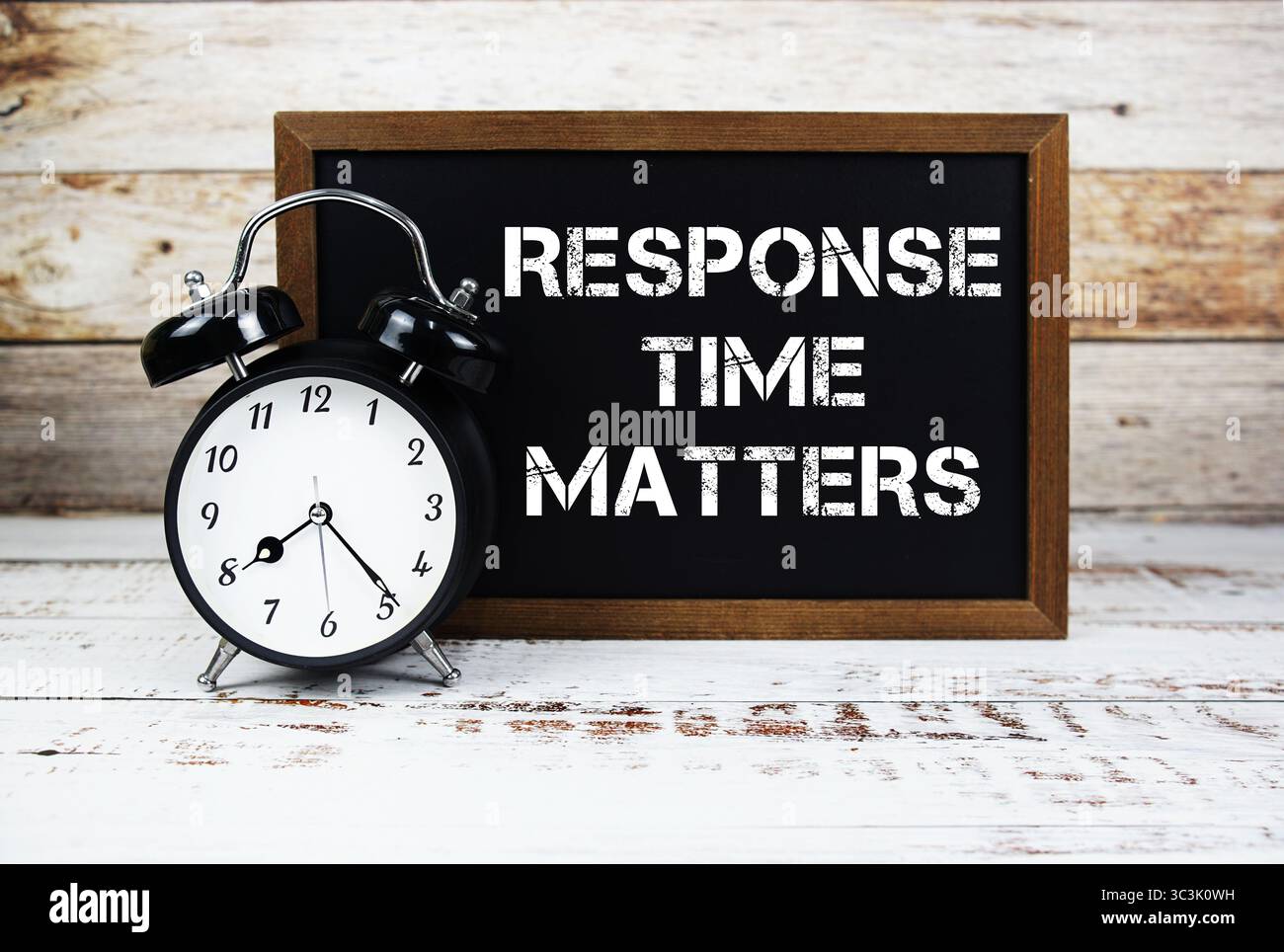 Il tempo di risposta è importante per i messaggi di testo e la sveglia su sfondo in legno Foto Stock