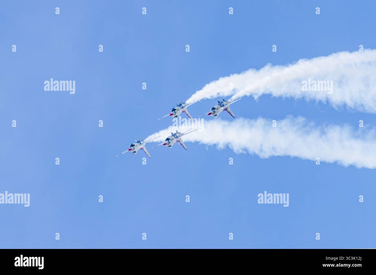 Quattro Thunderbirds dell'USAF eseguono una stretta salita di formazione con sentieri di fumo in una mostra aerea pubblica. Foto Stock