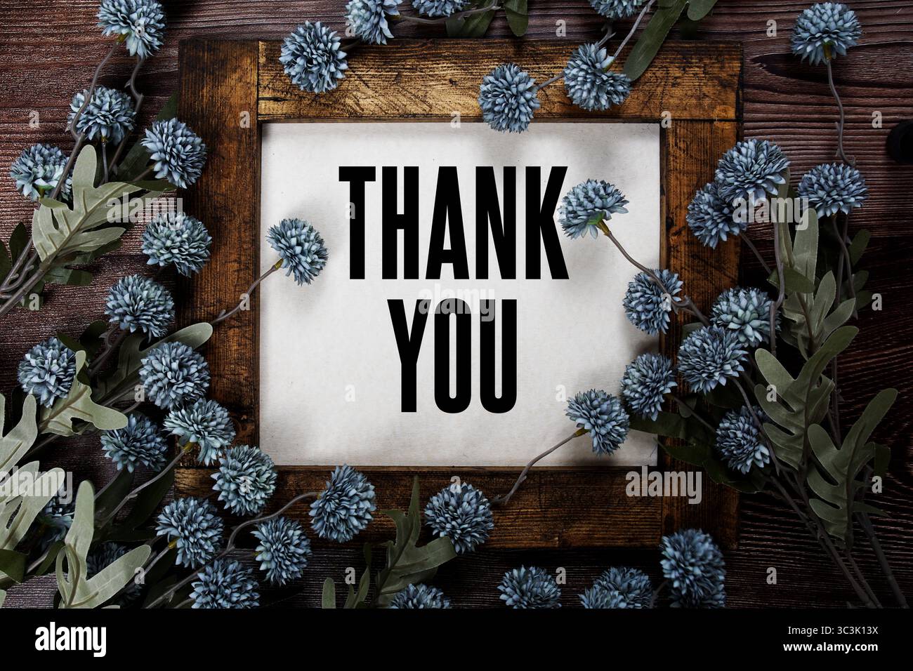 Testo di ringraziamento con decorazioni floreali su sfondo in legno Foto Stock