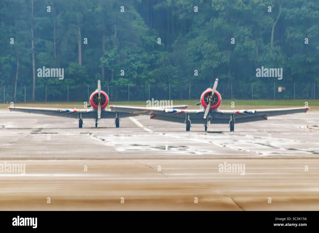 Diversi velivoli texani del Nord America T-6 siedono parcheggiati sulla rampa nella nebbia mattutina durante il Wings Over Wayne Air Show del 2023 presso la Seymour Johnson Air Force Foto Stock