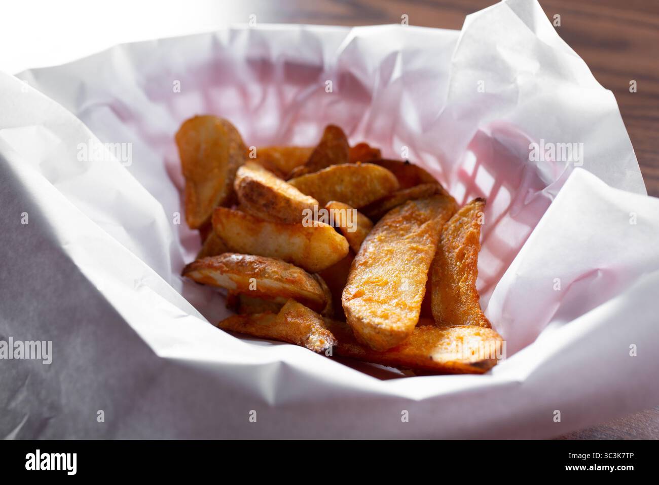 Vista di un cestino di patate a spicchi. Foto Stock