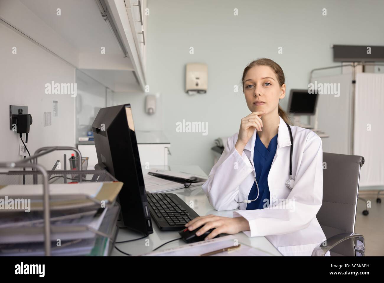 Medico sicuro che posa per il ritratto del profilo al computer in clinica Foto Stock
