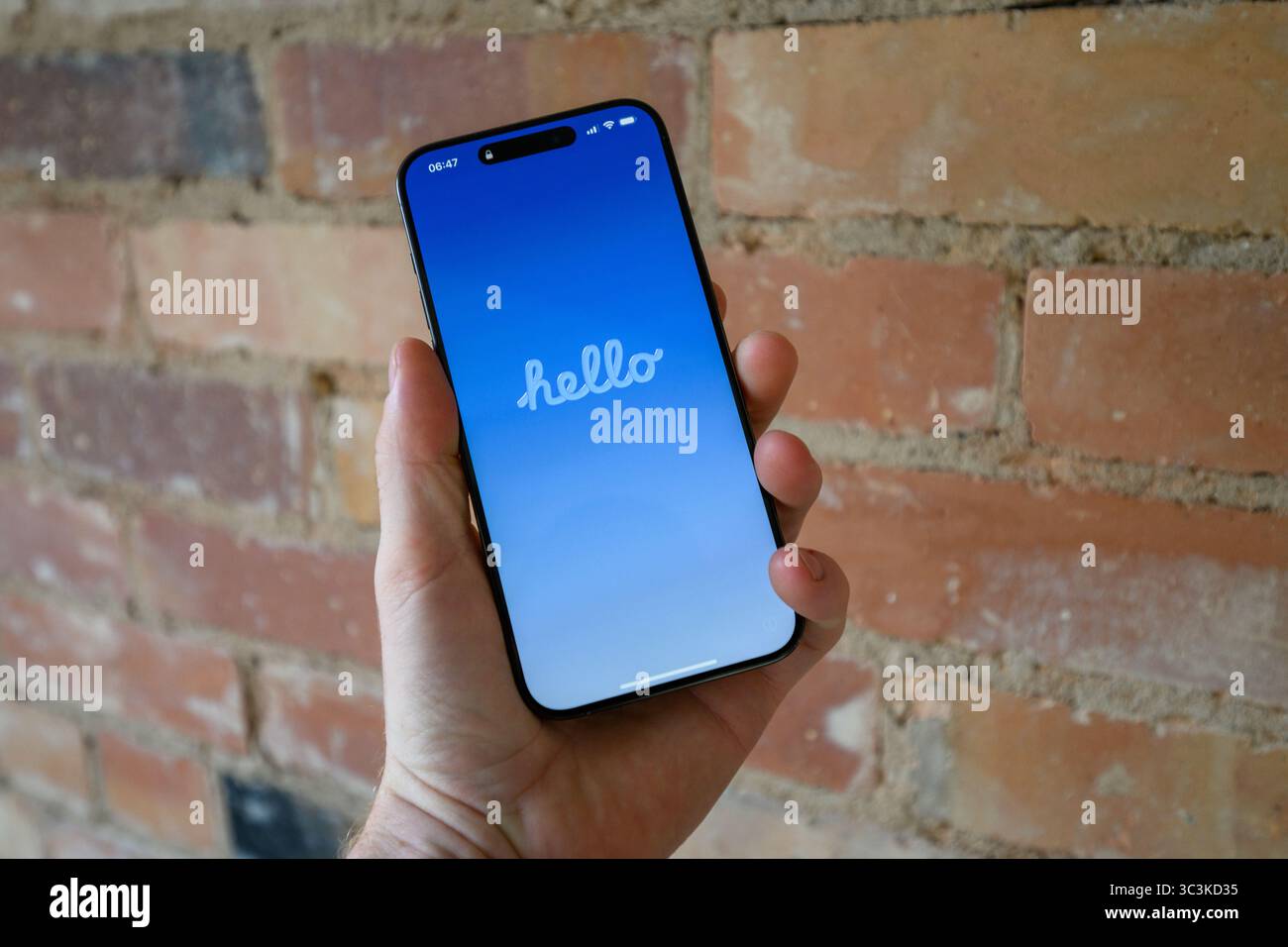 Questa immagine mostra un iPhone che ha appena completato l'aggiornamento di iOS 26, visualizzando ora la schermata di benvenuto multilingue Hello Foto Stock