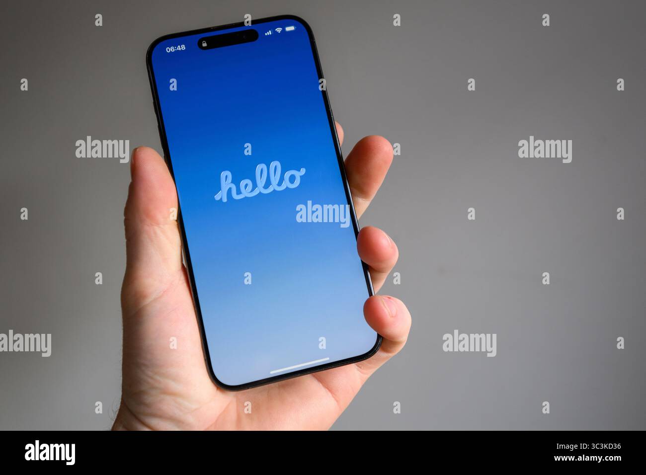 Questa immagine mostra un iPhone che ha appena completato l'aggiornamento di iOS 26, visualizzando ora la schermata di benvenuto multilingue Hello Foto Stock