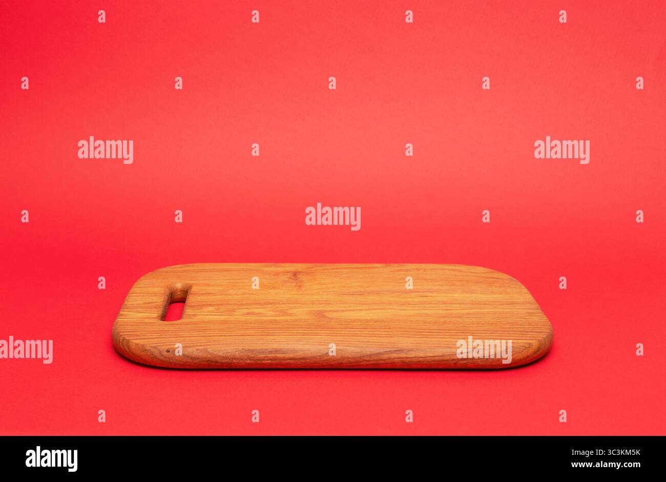 Tagliere in legno, podio per alimenti o prodotti su sfondo rosso Foto Stock