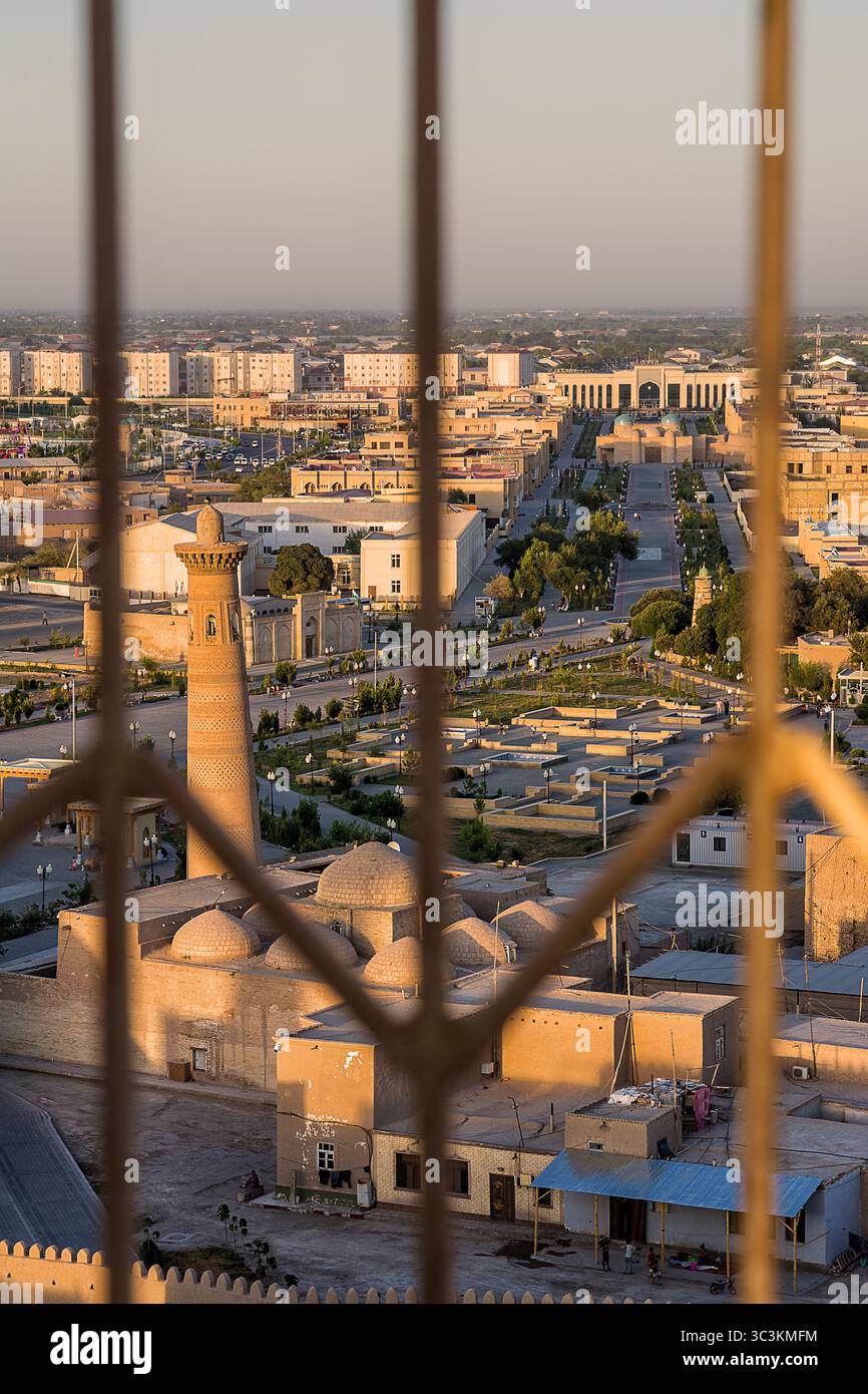 Khiva, Uzbekistan - 12 luglio 2024: Veduta aerea di un minareto che domina la città di Khiva, con la stazione ferroviaria visibile sullo sfondo lontano Foto Stock