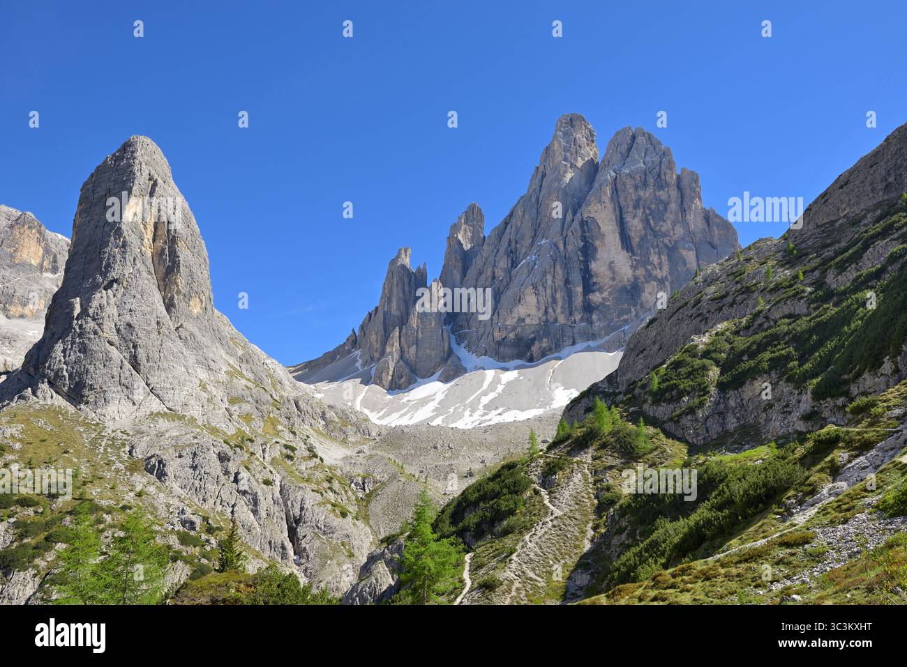 Vista panoramica di alte montagne con cime ripide, valle alpina sotto il cielo azzurro. Immagine di intestazione per la presentazione Wilderness in the Dolomites. Foto Stock