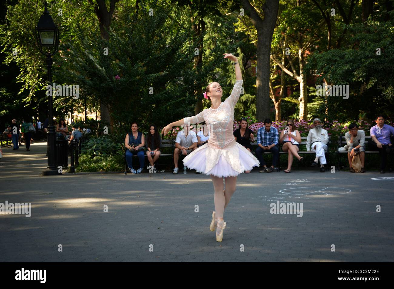 Una graziosa ballerina in piedi sui piedi con l'aiuto di scarpe pointe. Nel Washington Square Park a Manhattan, New York. Foto Stock