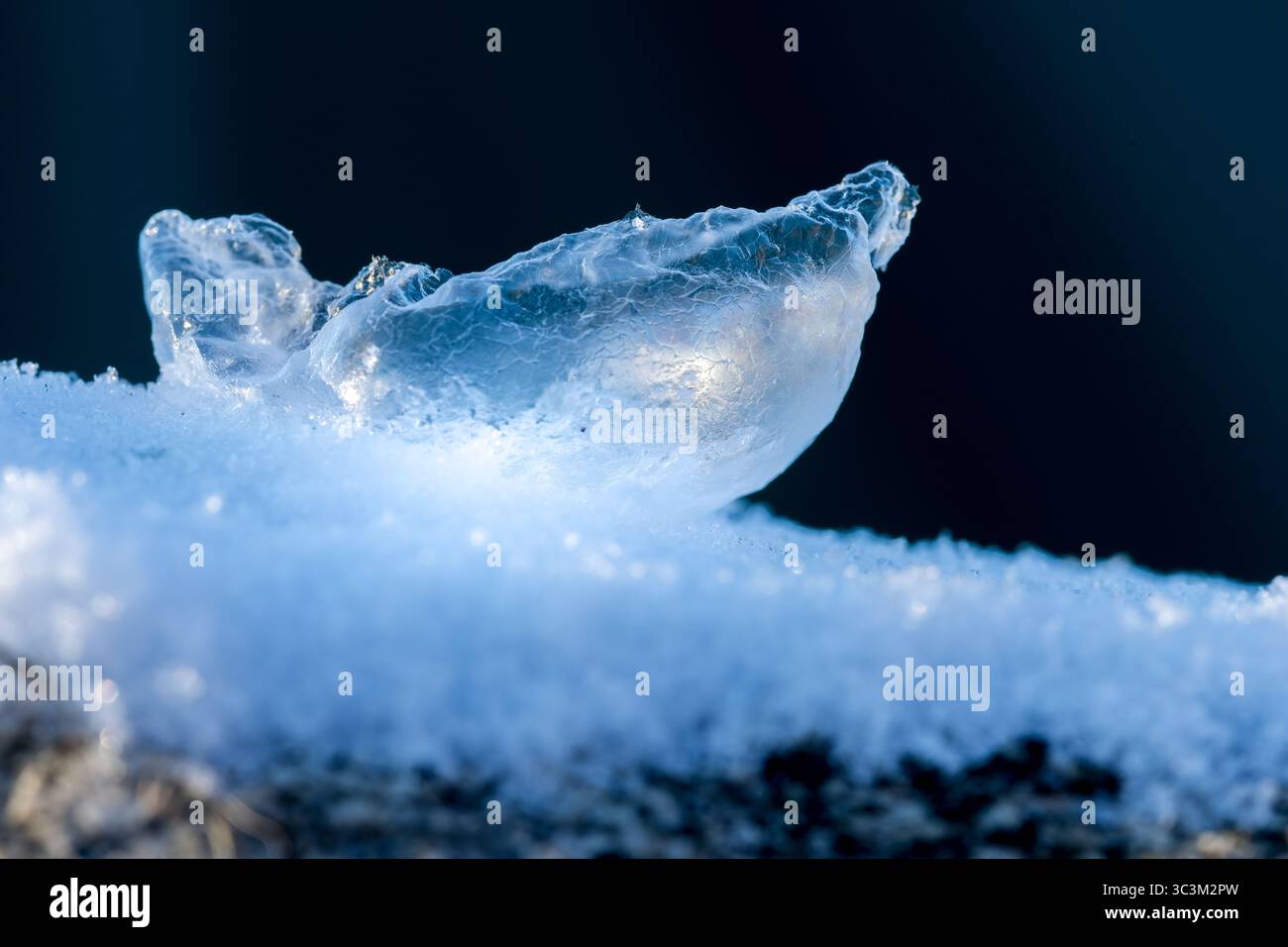 Bolle di sapone congelato rotte sulla neve e sullo sfondo scuro Foto Stock