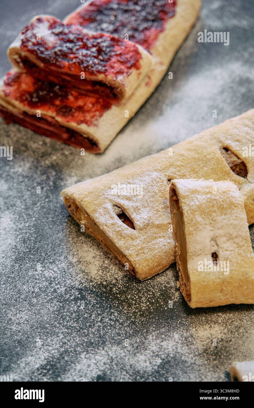 Dolci squisitamente sfornati ripieni di confettura dolce e zucchero a velo che offrono un'allettante delizia per qualsiasi palato di dessert Foto Stock