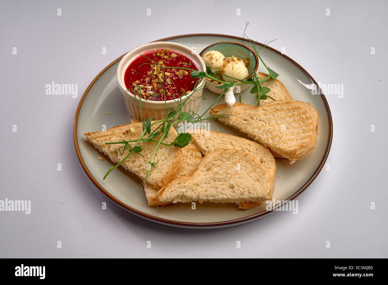 Delizioso toast Gourmet con zuppa di pomodoro guarnita con erbe e spezie servito su un piatto classico per un'esperienza culinaria perfetta Foto Stock