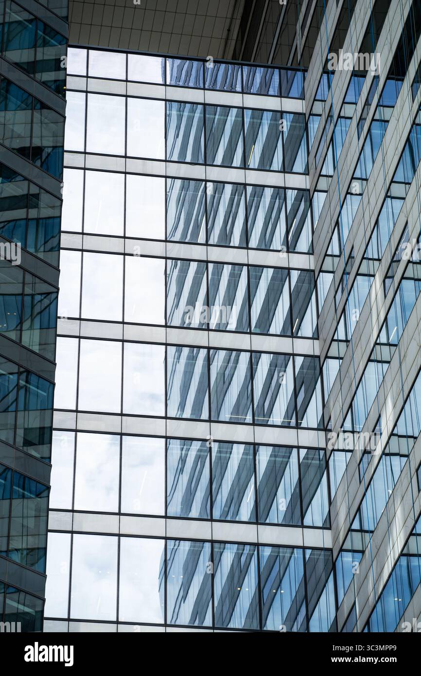 Una suggestiva vista della moderna architettura cittadina caratterizzata da strutture in vetro e acciaio. I riflessi creano un motivo dinamico, che mette in risalto lo stile contemporaneo Foto Stock