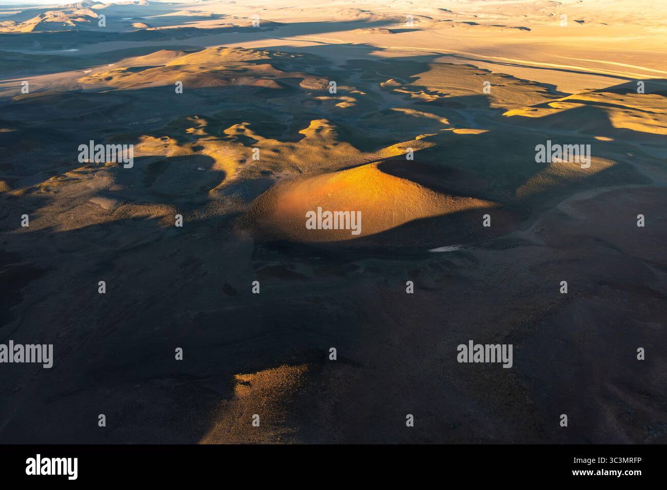 Vista aerea che cattura l'aspro paesaggio vulcanico di la Puna, Argentina. Questa prospettiva dall'alto verso il basso mette in risalto le texture e i colori drammatici di questo modello Foto Stock