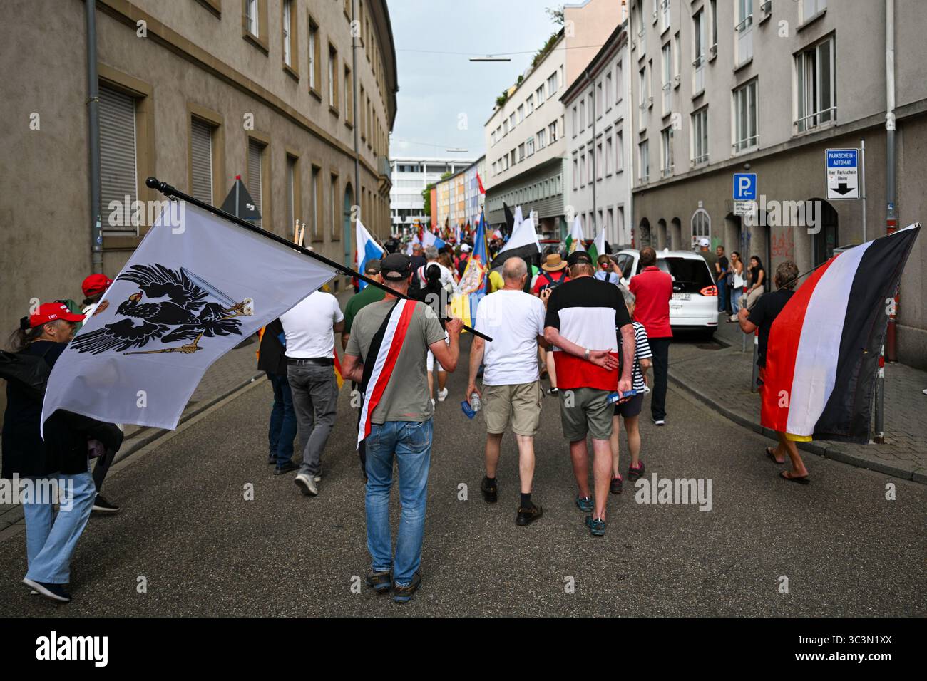 Karlsruhe, Germania. 26 luglio 2025. I partecipanti a una manifestazione di "Reichsbürger" marciano attraverso il centro della città con bandiere. La riunione del Reichsbürger è stata registrata con il motto "la sesta grande riunione degli stati federali, della patria e della pace nel mondo”. Credito: FRM/dpa/Alamy Live News Foto Stock