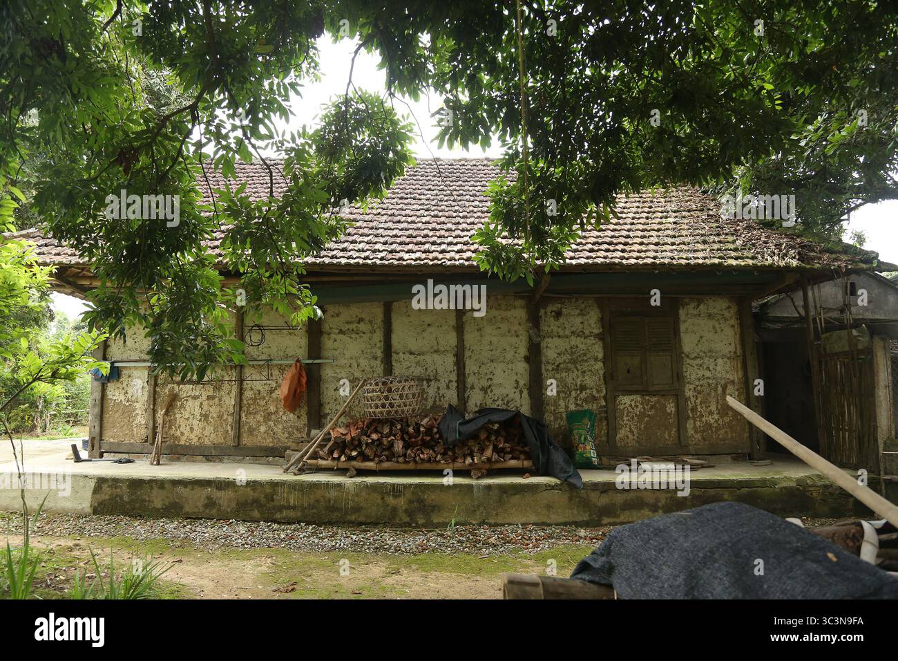 Una vecchia casa con colonne e travi in legno, pareti in terra e tetto piastrellato a Dien Bien, Vietnam. La casa è molto calda in inverno e fresca in estate. Foto Stock