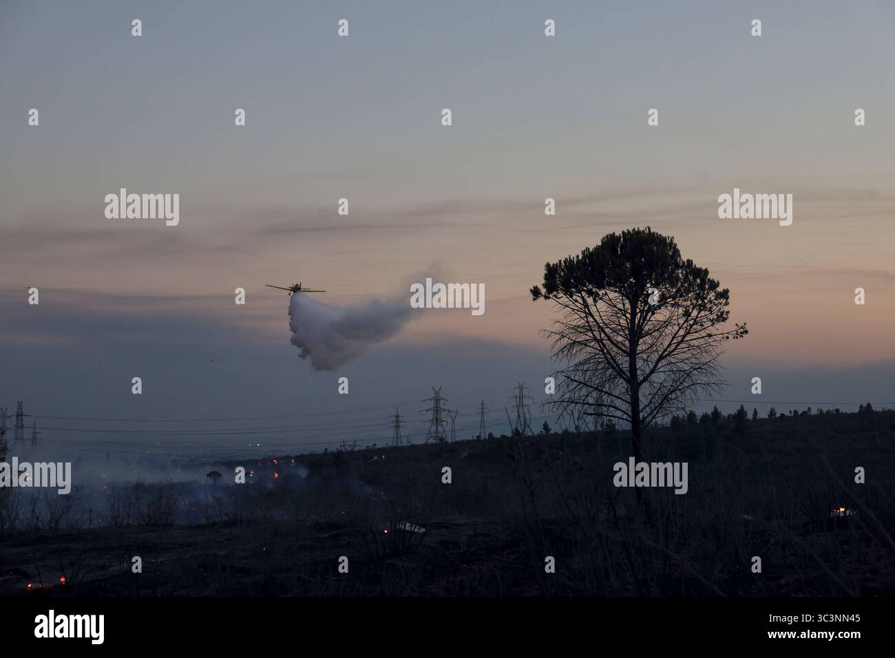 An aircraft drops water over a fire, in the northwestern suburb of Kryoneri, in Athens, Greece, Saturday, July 26, 2025. (AP Photo/Yorgos Karahalis) Foto Stock