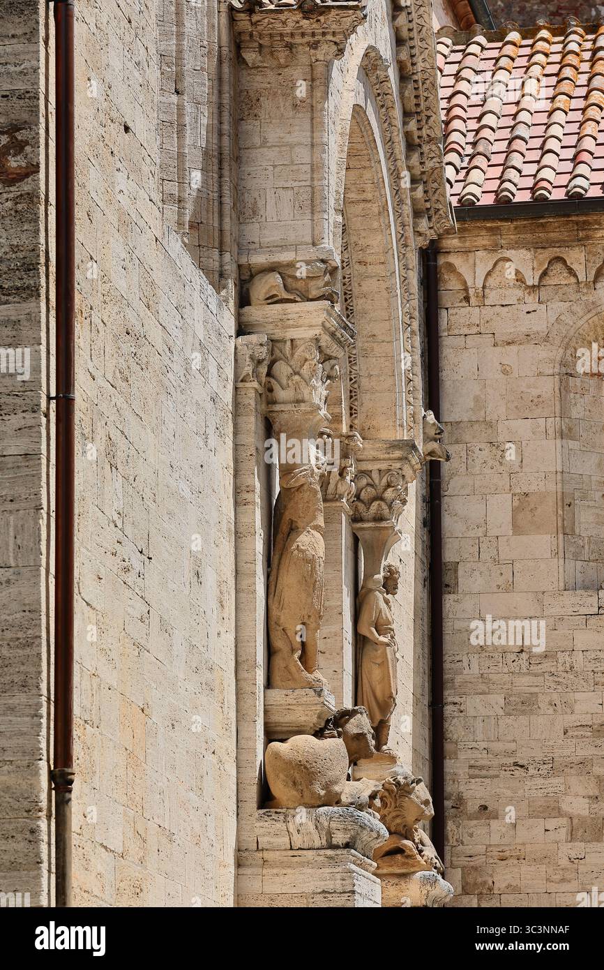 122 Collegiata dei Santi Quirico e Giulitta, portale laterale romanico-gotico fiancheggiato da due cariatidi appoggiati su leoni. San Quirico d'Orcia, Italia Foto Stock