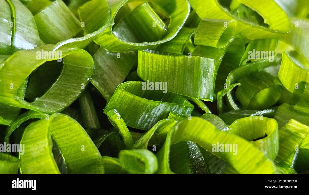 Cipolle verdi appena tritate: Primo piano delle fette di cipolla primaverile - Immagine stock catturata con smartphone