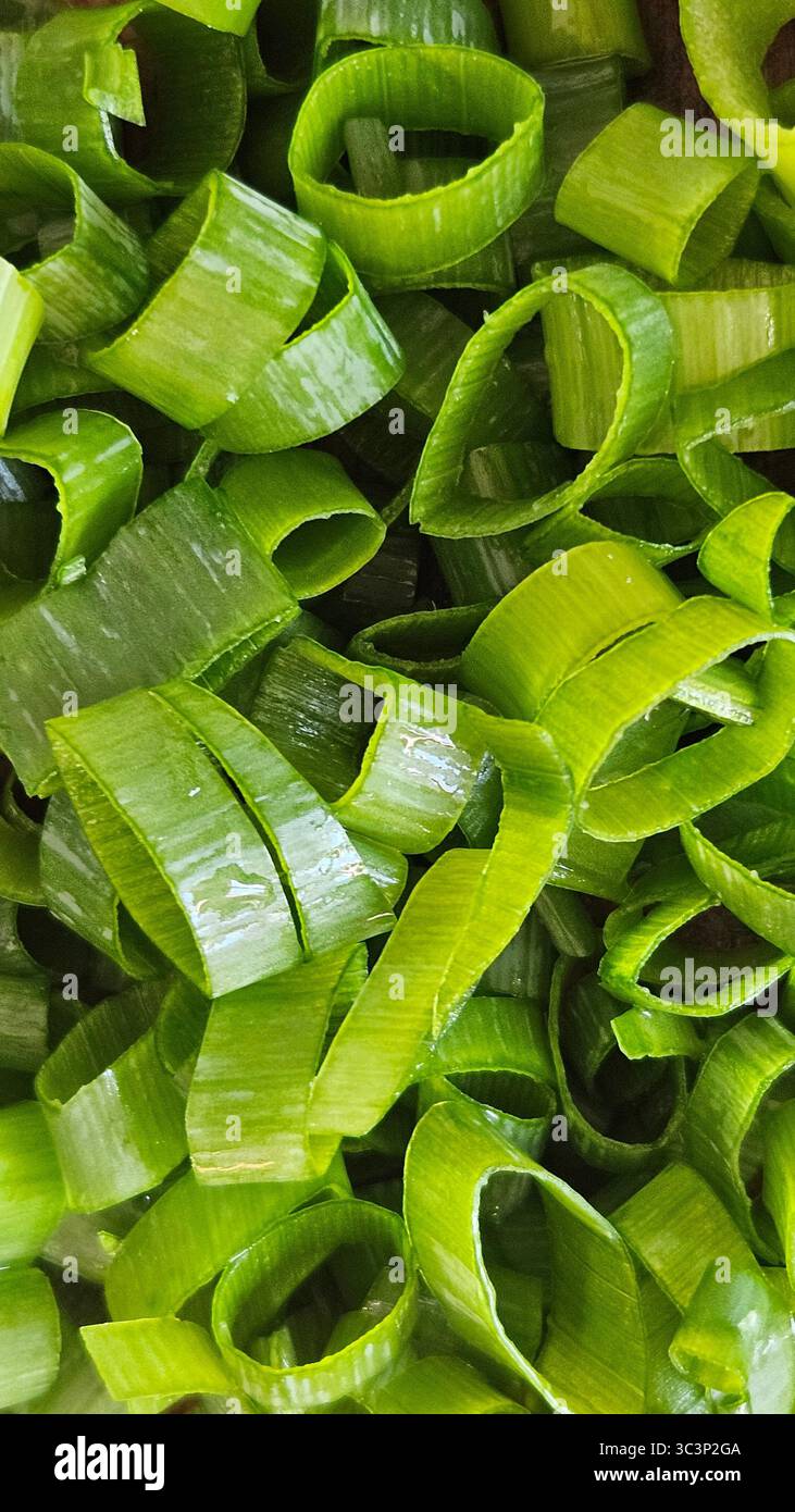 Cipolle verdi appena tritate: Primo piano delle fette di cipolla primaverile - Immagine stock catturata con smartphone