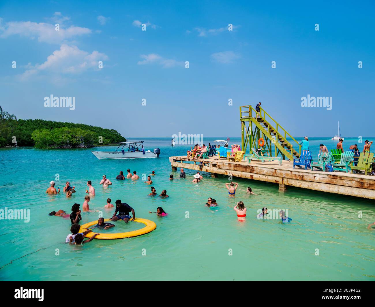 Persone che nuotano al Lazy Lizard Bar and Grill, The Split, Caye Caulker, Belize District, Belize Foto Stock