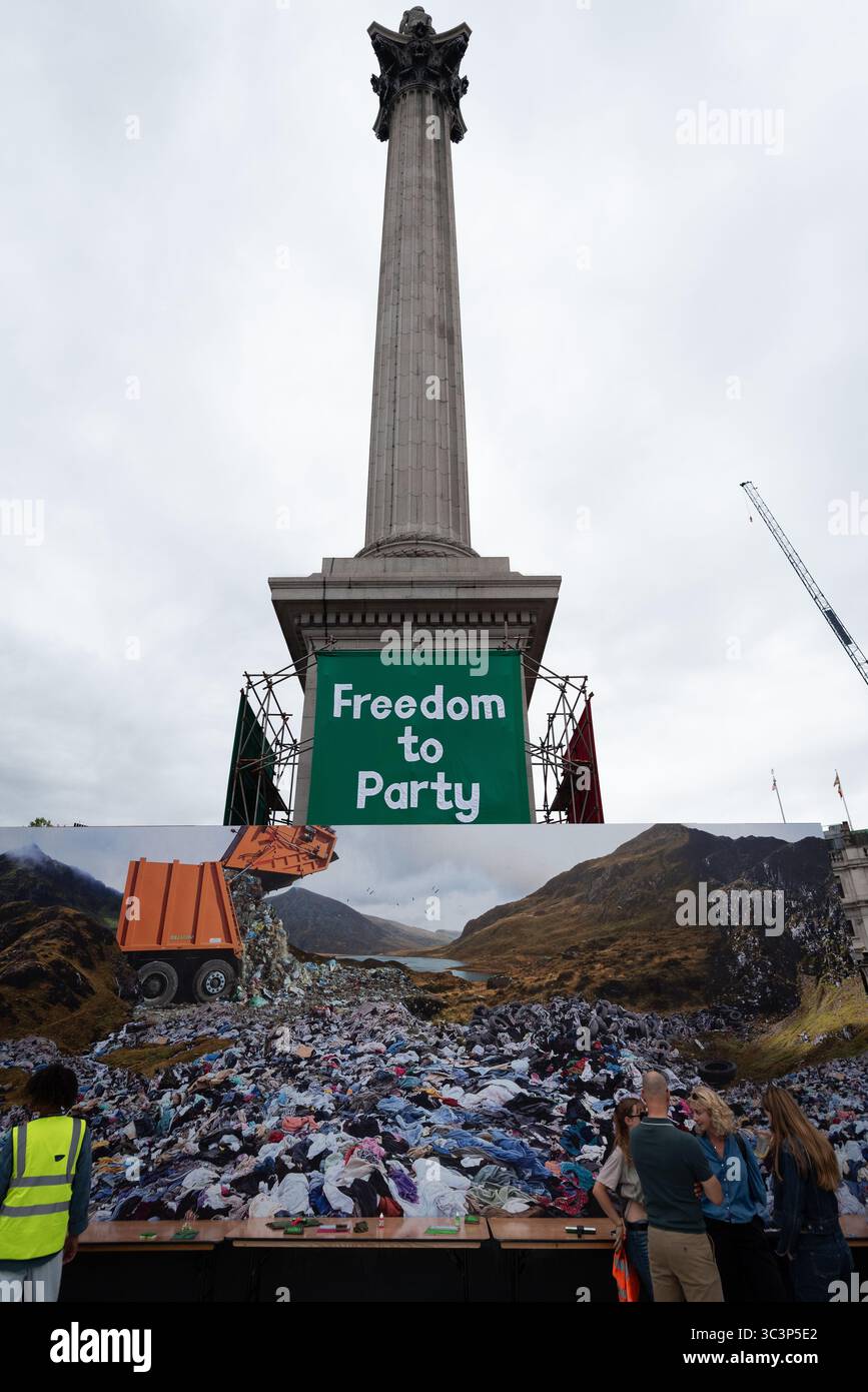 Londra, Regno Unito. 26 luglio 2025. Un grande banner verde con la scritta "Freedom to Party" è appeso alla colonna di Nelson mentre Trafalgar Square è decorata con opere d'arte organizzate da Jeremy Deller come parte delle celebrazioni del bicentenario della National Gallery. In primo piano viene mostrata un'enorme immagine di un paesaggio rovinato dai rifiuti umani. Crediti: Ron Fassbender/Alamy Live News Foto Stock Londra, Regno Unito. 26 luglio 2025. Un grande banner verde con la scritta "Freedom to Party" è appeso alla colonna di Nelson mentre Trafalgar Square è decorata con opere d'arte organizzate da Jeremy Deller come parte delle celebrazioni del bicentenario della National Gallery. In primo piano viene mostrata un'enorme immagine di un paesaggio rovinato dai rifiuti umani. Crediti: Ron Fassbender/Alamy Live News Foto Stock