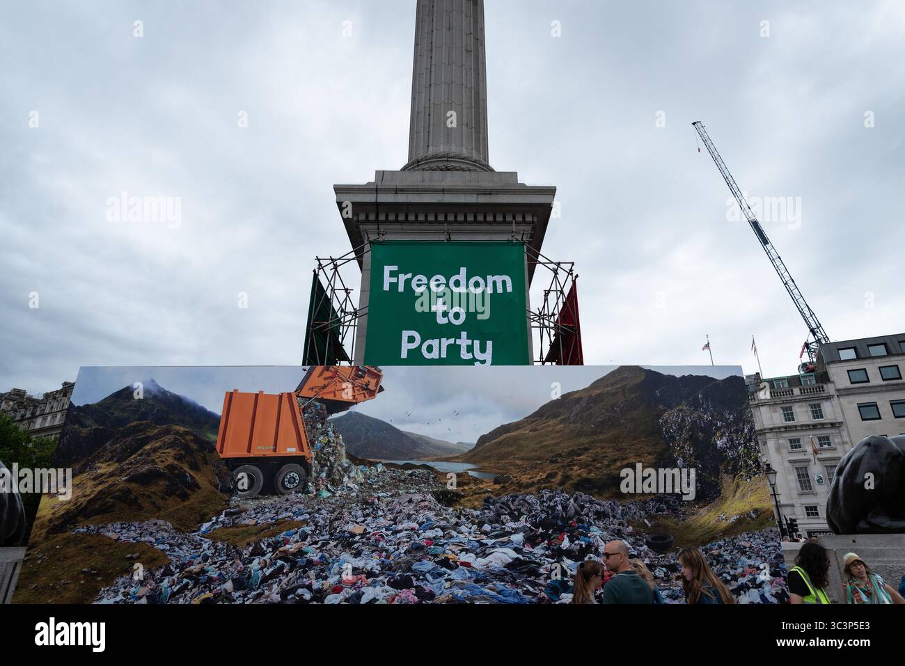 Londra, Regno Unito. 26 luglio 2025. Un grande banner verde con la scritta "Freedom to Party" è appeso alla colonna di Nelson mentre Trafalgar Square è decorata con opere d'arte organizzate da Jeremy Deller come parte delle celebrazioni del bicentenario della National Gallery. In primo piano viene mostrata un'enorme immagine di un paesaggio rovinato dai rifiuti umani. Crediti: Ron Fassbender/Alamy Live News Foto Stock Londra, Regno Unito. 26 luglio 2025. Un grande banner verde con la scritta "Freedom to Party" è appeso alla colonna di Nelson mentre Trafalgar Square è decorata con opere d'arte organizzate da Jeremy Deller come parte delle celebrazioni del bicentenario della National Gallery. In primo piano viene mostrata un'enorme immagine di un paesaggio rovinato dai rifiuti umani. Crediti: Ron Fassbender/Alamy Live News Foto Stock